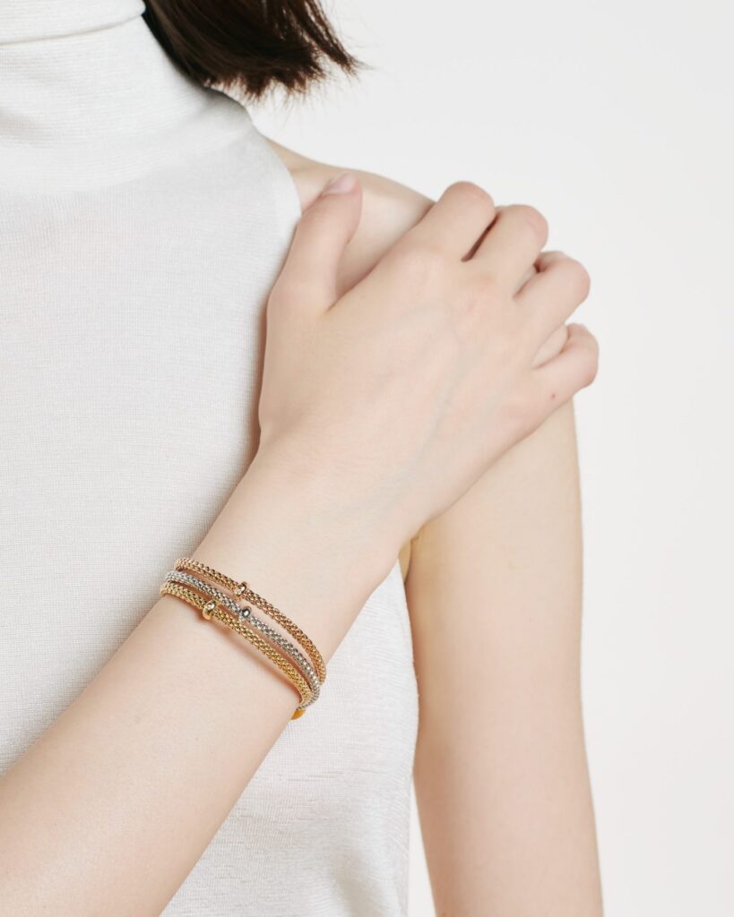 fope prima bracelets in 3 shades of gold worn around wrist of model