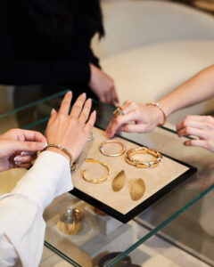 bua trying on different italian gold jewelry pieces from scintilla
