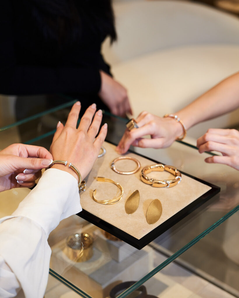 bua trying on different italian gold jewelry pieces from scintilla